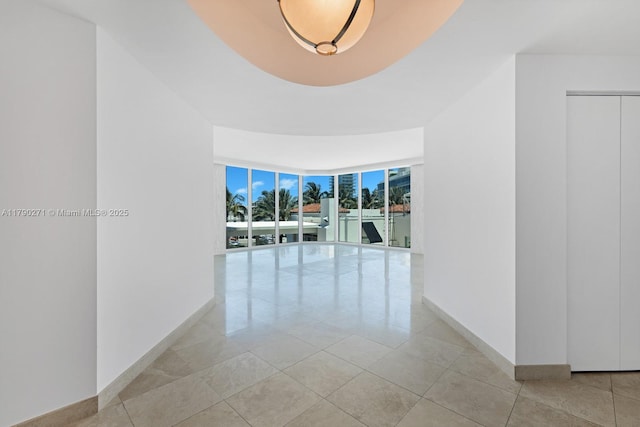 300 S Pointe Dr Unit 405, Miami Beach, FL 33139 - corridor featuring a wall of windows, baseboards, and light tile patterned floors
