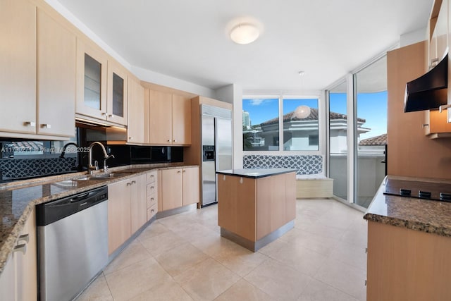 300 S Pointe Dr Unit 405, Miami Beach, FL 33139 - kitchen with stainless steel appliances, a sink, a healthy amount of sunlight, light brown cabinets, and a kitchen island