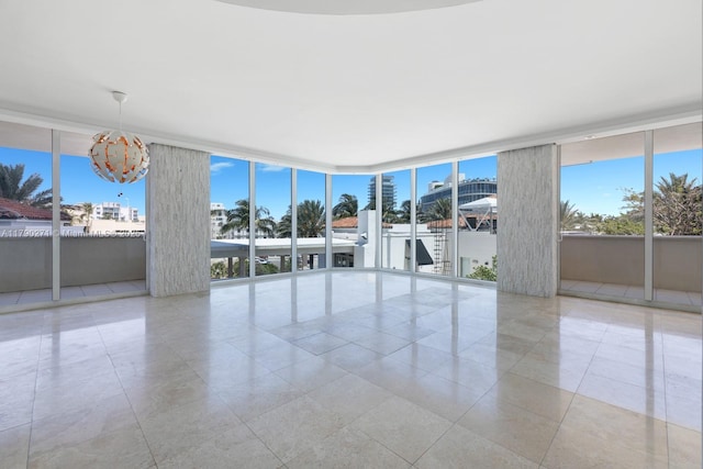 300 S Pointe Dr Unit 405, Miami Beach, FL 33139 - tiled empty room with a notable chandelier and a wall of windows