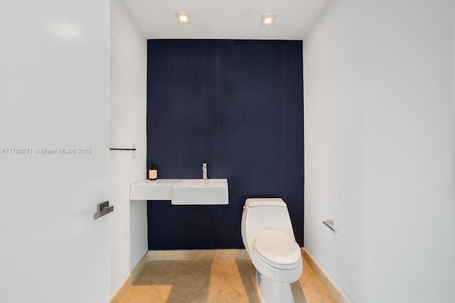 300 S Pointe Dr Unit 405, Miami Beach, FL 33139 - half bath with an accent wall, toilet, baseboards, and a sink