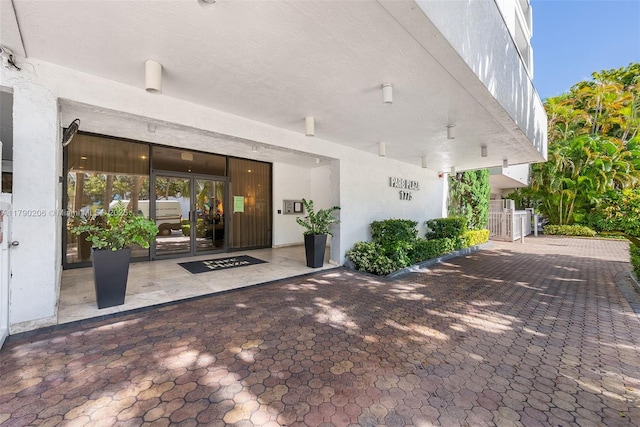1775 Washington Ave Unit 11C, Miami Beach, FL 33139 - view of exterior entry featuring stucco siding and french doors
