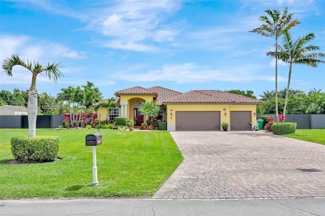 mediterranean / spanish-style home featuring decorative driveway, a front lawn, fence, a garage, and stucco siding