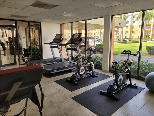 9360 Fontainebleau Blvd Unit 208, Miami, FL 33172 - workout area featuring a wall of windows, tile patterned flooring, and a paneled ceiling