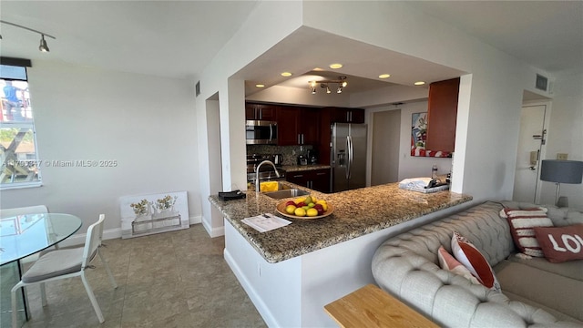 16570 NE 26th Ave Unit 4A, North Miami Beach, FL 33160 - kitchen with stainless steel appliances, a sink, stone countertops, tasteful backsplash, and rail lighting
