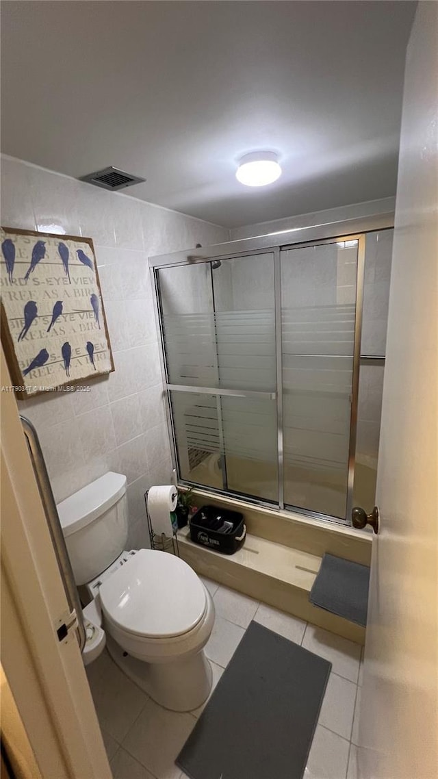 16570 NE 26th Ave Unit 4A, North Miami Beach, FL 33160 - bathroom featuring tile patterned flooring, toilet, a stall shower, and tile walls