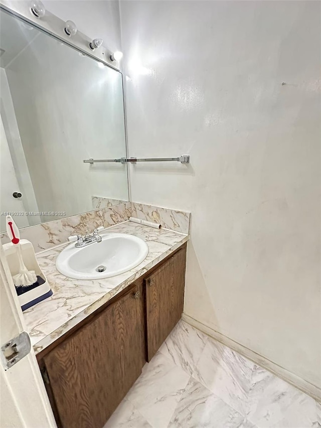 bathroom featuring vanity, marble finish floor, and baseboards