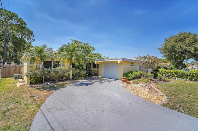 view of front facade featuring fence, a front lawn, a garage, stucco siding, and driveway