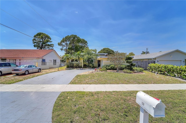 view of front of house with fence, driveway, and a front yard