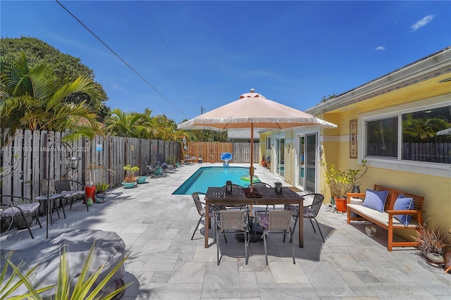 view of pool with a fenced backyard, a fenced in pool, a patio, and outdoor dining space