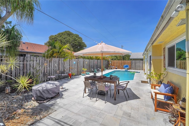 view of swimming pool with a patio, a fenced in pool, outdoor dining area, and a fenced backyard