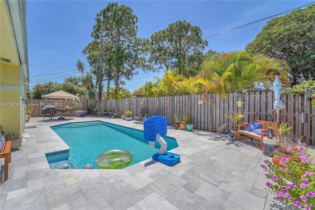 view of swimming pool with a fenced in pool, a fenced backyard, and a patio area