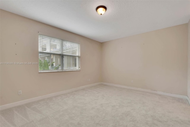 unfurnished room featuring baseboards, carpet flooring, and a textured ceiling