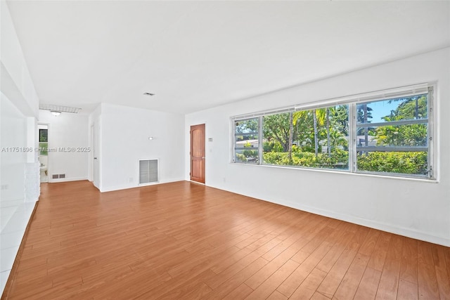 10635 NE 11th Ct, Miami Shores, FL 33138 - unfurnished living room with baseboards, visible vents, and wood finished floors
