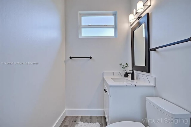 5224 Columbus Blvd, Sebring, FL 33872 - half bathroom featuring toilet, vanity, wood finished floors, and baseboards