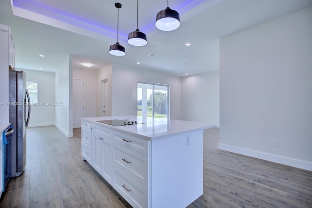 5224 Columbus Blvd, Sebring, FL 33872 - kitchen featuring white cabinets, baseboards, wood finished floors, and black electric cooktop