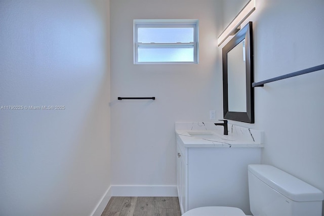 5224 Columbus Blvd, Sebring, FL 33872 - half bath featuring baseboards, wood finished floors, vanity, and toilet