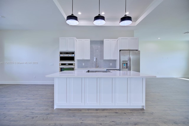 5224 Columbus Blvd, Sebring, FL 33872 - kitchen featuring stainless steel appliances, light countertops, white cabinetry, tasteful backsplash, and light wood-style flooring