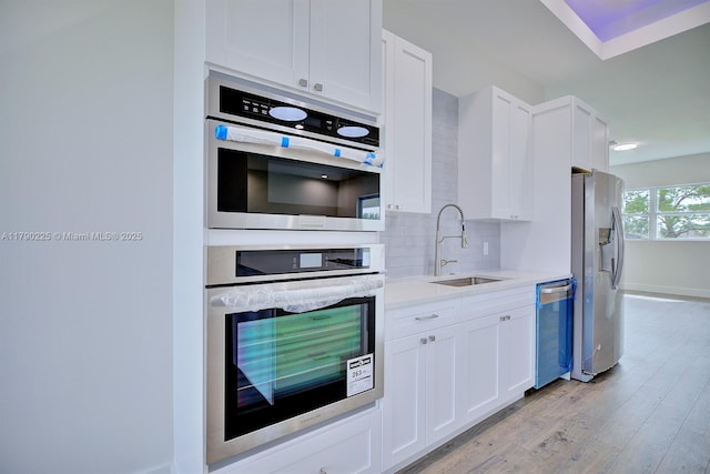 5224 Columbus Blvd, Sebring, FL 33872 - kitchen featuring appliances with stainless steel finishes, a sink, backsplash, and white cabinetry