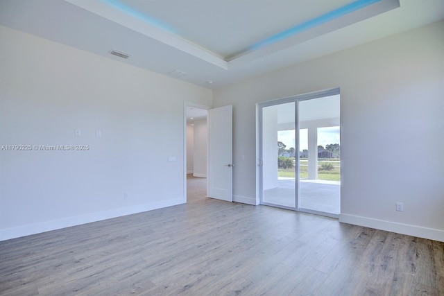 5224 Columbus Blvd, Sebring, FL 33872 - spare room featuring visible vents, baseboards, wood finished floors, and a tray ceiling