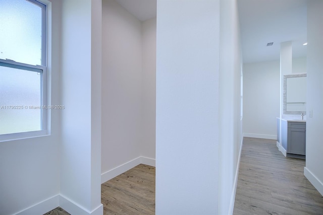 5224 Columbus Blvd, Sebring, FL 33872 - hall featuring visible vents, light wood finished floors, baseboards, and a sink