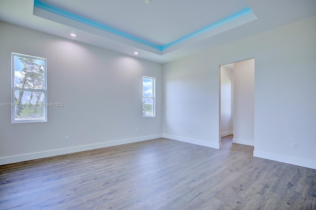 5224 Columbus Blvd, Sebring, FL 33872 - empty room with a tray ceiling, healthy amount of natural light, recessed lighting, wood finished floors, and baseboards