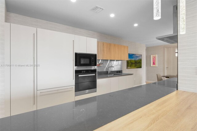 1000 Brickell Plz Unit Ph5603, Miami, FL 33131 - kitchen with wall oven, built in microwave, a sink, wall chimney exhaust hood, and dark countertops