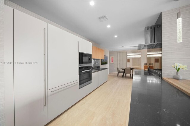 1000 Brickell Plz Unit Ph5603, Miami, FL 33131 - kitchen with black appliances, recessed lighting, range hood, modern cabinets, and white cabinetry