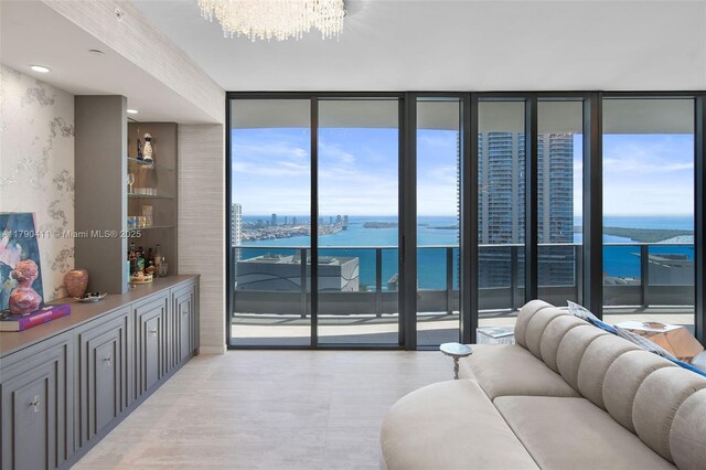 1000 Brickell Plz Unit Ph5603, Miami, FL 33131 - living room featuring a water view, floor to ceiling windows, a chandelier, and light wood-style flooring