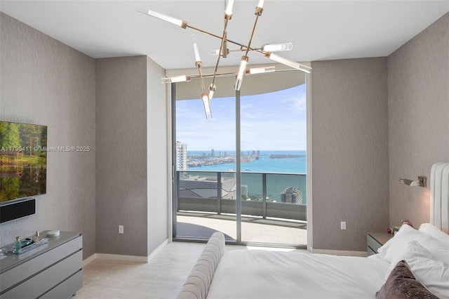 1000 Brickell Plz Unit Ph5603, Miami, FL 33131 - bedroom with a chandelier, access to exterior, wallpapered walls, a water view, and expansive windows