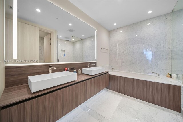 1000 Brickell Plz Unit Ph5603, Miami, FL 33131 - bathroom with a garden tub, recessed lighting, double vanity, a shower, and tile walls