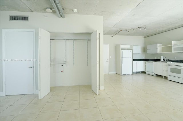 690 SW 1st Ct Unit 2032, Miami, FL 33130 - kitchen with white appliances, dark countertops, white cabinetry, open shelves, and light tile patterned floors