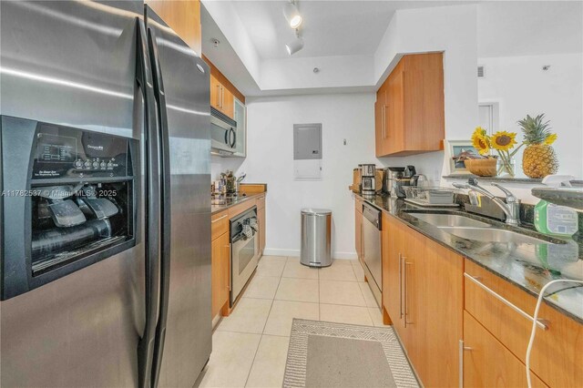 335 S Biscayne Blvd Unit 2003, Miami, FL 33131 - kitchen featuring a sink, stainless steel appliances, light tile patterned floors, dark stone countertops, and brown cabinetry