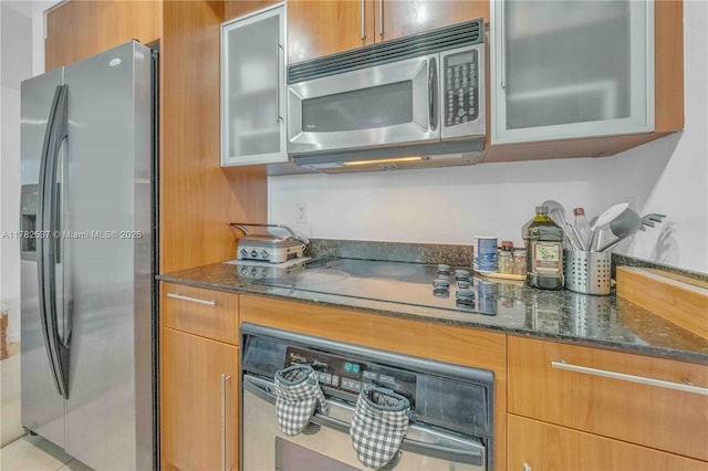 335 S Biscayne Blvd Unit 2003, Miami, FL 33131 - kitchen featuring glass insert cabinets, dark stone countertops, and stainless steel appliances