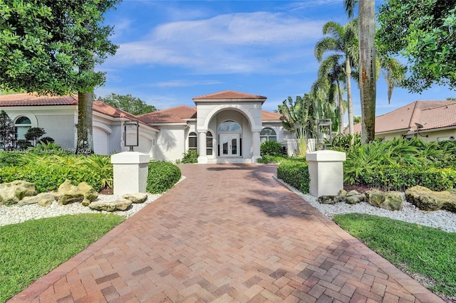 2670 Cypress Ln, Weston, FL 33332 - mediterranean / spanish-style house with a tile roof, decorative driveway, stucco siding, and french doors
