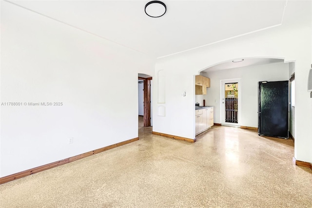 8440 NE 1st Ave, Miami, FL 33138 - unfurnished living room with baseboards, arched walkways, and light speckled floor