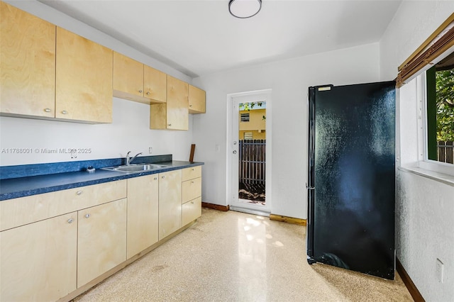 8440 NE 1st Ave, Miami, FL 33138 - kitchen featuring a sink, dark countertops, baseboards, freestanding refrigerator, and light brown cabinets