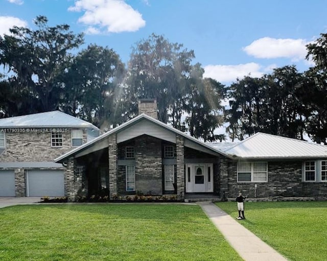 15618 SE US Highway 301, Hawthorne, FL 32640 - view of front facade featuring a chimney, a front yard, stone siding, and a garage