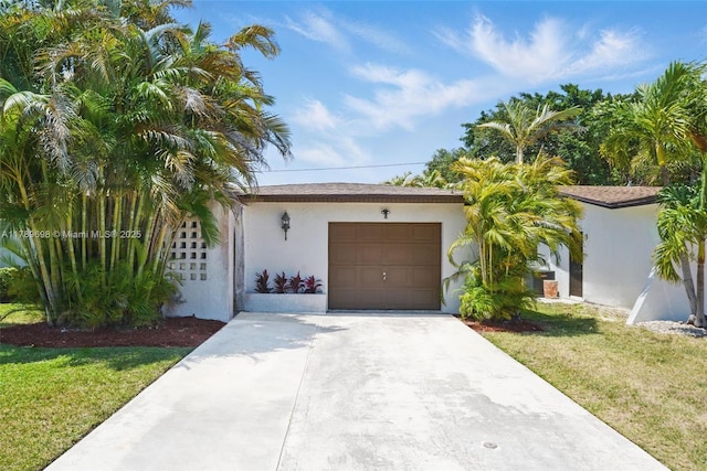 ranch-style house with a garage, driveway, a front yard, and stucco siding
