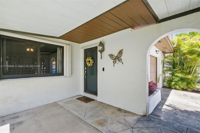 doorway to property featuring stucco siding and a patio area