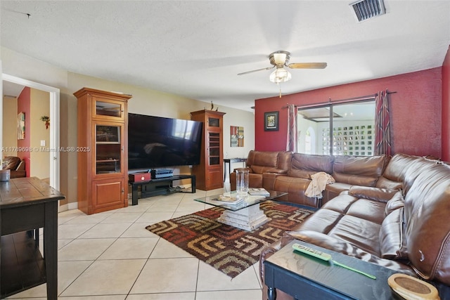 living room with visible vents, a ceiling fan, and light tile patterned floors