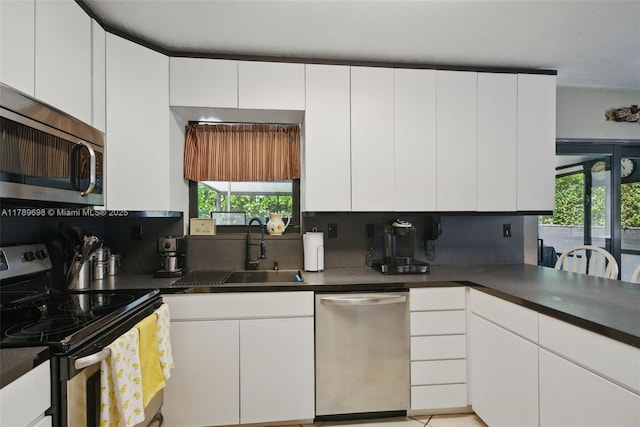 kitchen featuring stainless steel appliances, a sink, and white cabinetry