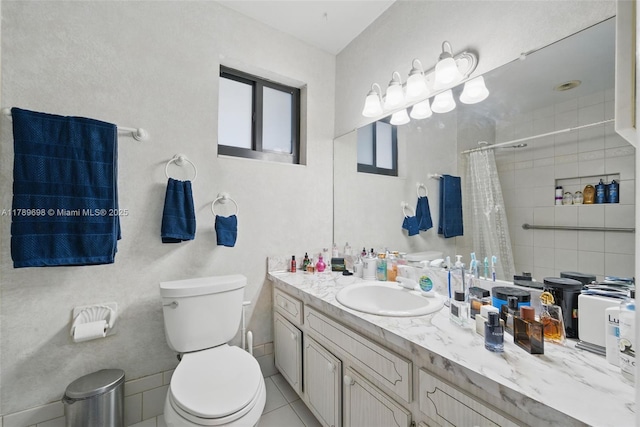 bathroom featuring a tile shower, toilet, and vanity