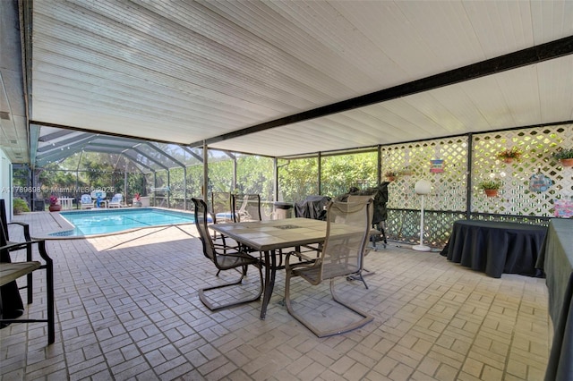 pool featuring glass enclosure, a patio area, and outdoor dining space