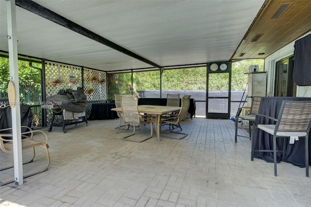sunroom / solarium featuring outdoor dining area and a healthy amount of sunlight