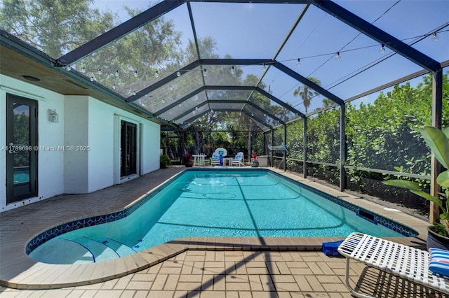 pool featuring a patio area and glass enclosure
