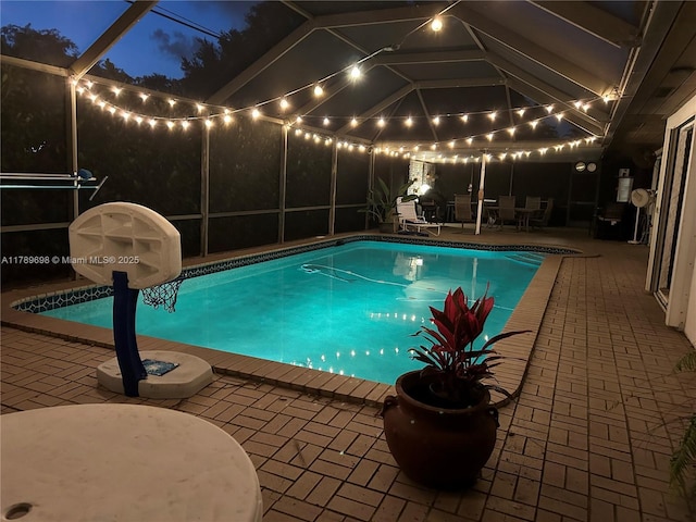 outdoor pool with glass enclosure and a patio