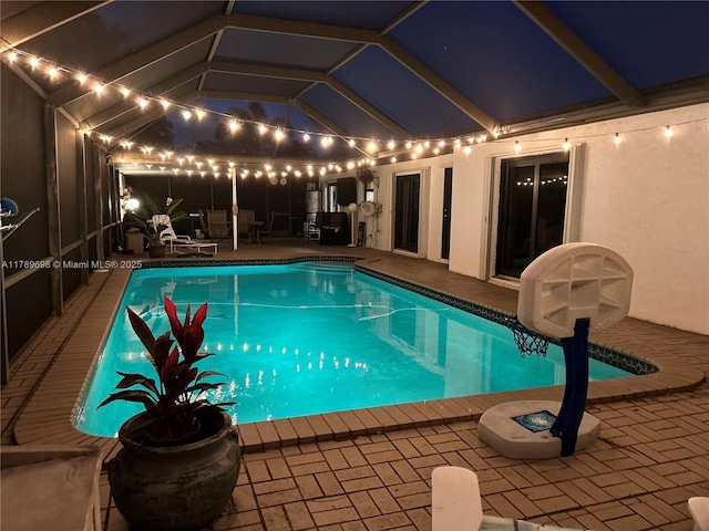 pool at twilight featuring an outdoor pool and a patio