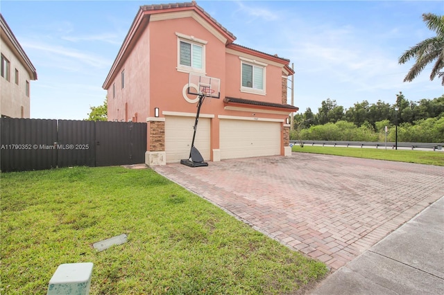 view of side of home with a tile roof, stone siding, an attached garage, stucco siding, and decorative driveway