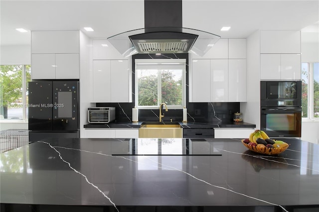 kitchen with dark countertops, a sink, black appliances, modern cabinets, and white cabinets