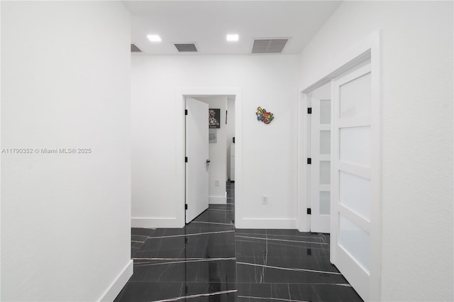 hall with visible vents and baseboards